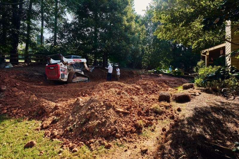 excavator digging the footing for a retaining wall in Forsyth County GA